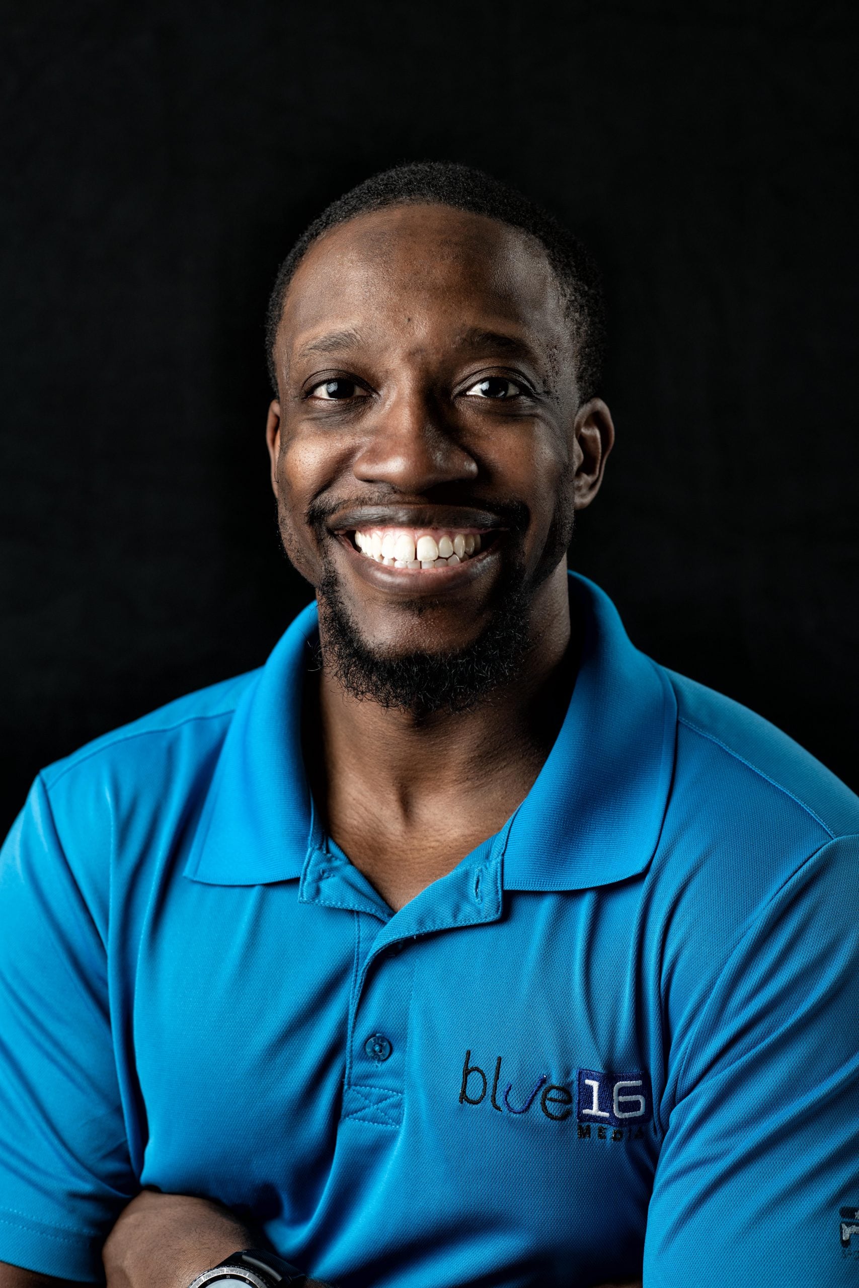 Headshot of Gresham Harkless Jr. - man smiling wearing blue shirt with logo Blue 16 Media Headshot of Gresham Harkless Jr. - man smiling wearing blue shirt with logo Blue 16 Media