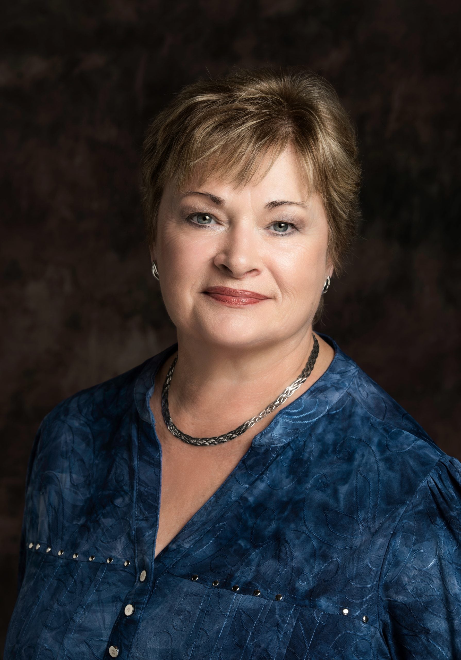 LorraineNewPhoto2 Lorraine Lane headshot - a white woman with short brown hair wearing a blue blouse