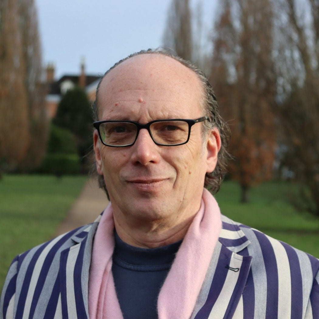 Marc Jarrett headshot 1 square Headshot of Marc Jarret outdoors, wearing glasses and a striped jacket